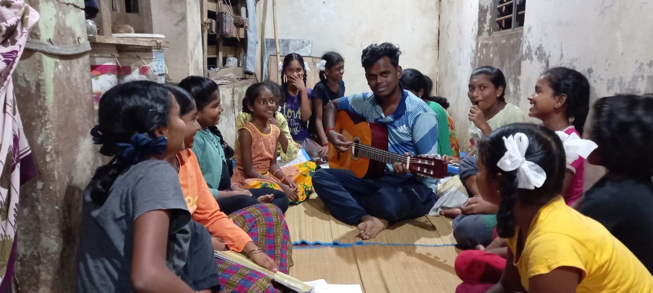 Sarvin Kumar in Atsjarampet playing music with the kids.