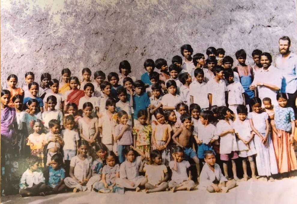 Ivar Jenten with the kids in front of roof of night school Auroville India 1980