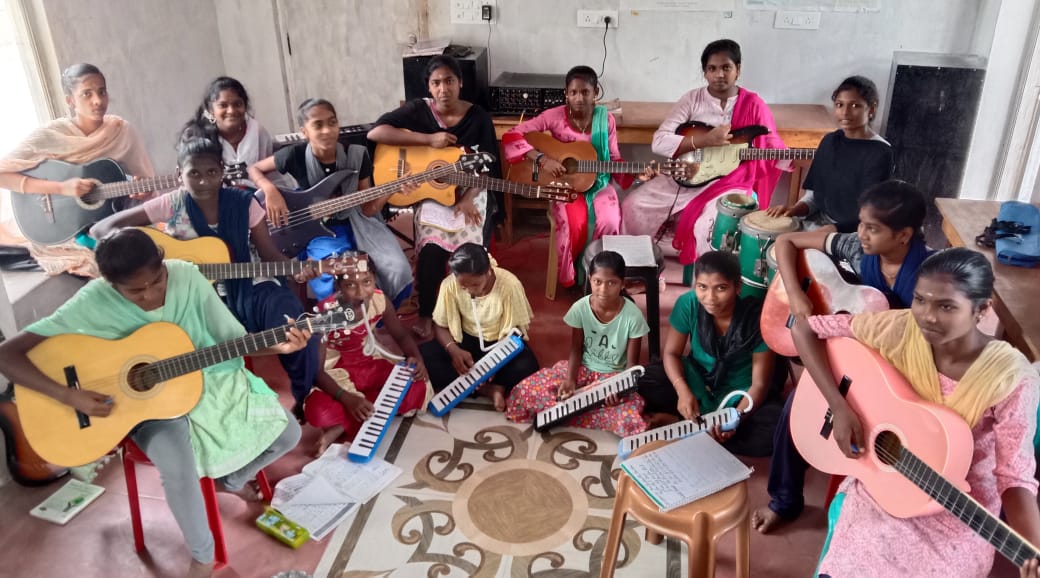 Playing Melodica and guitar music kids Isai Ragam Auroville India